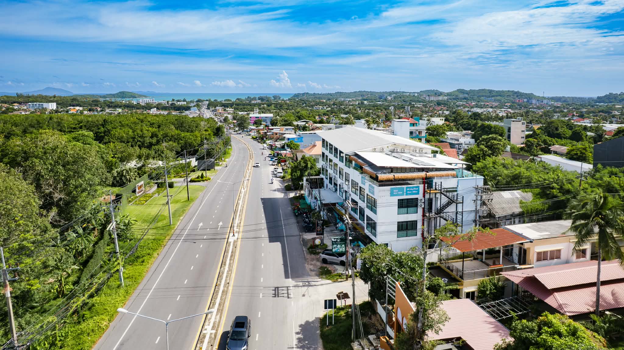 Aerial view of De Blue Sea Rawai Hotel on Wiset Road with Chalong Bay beyond