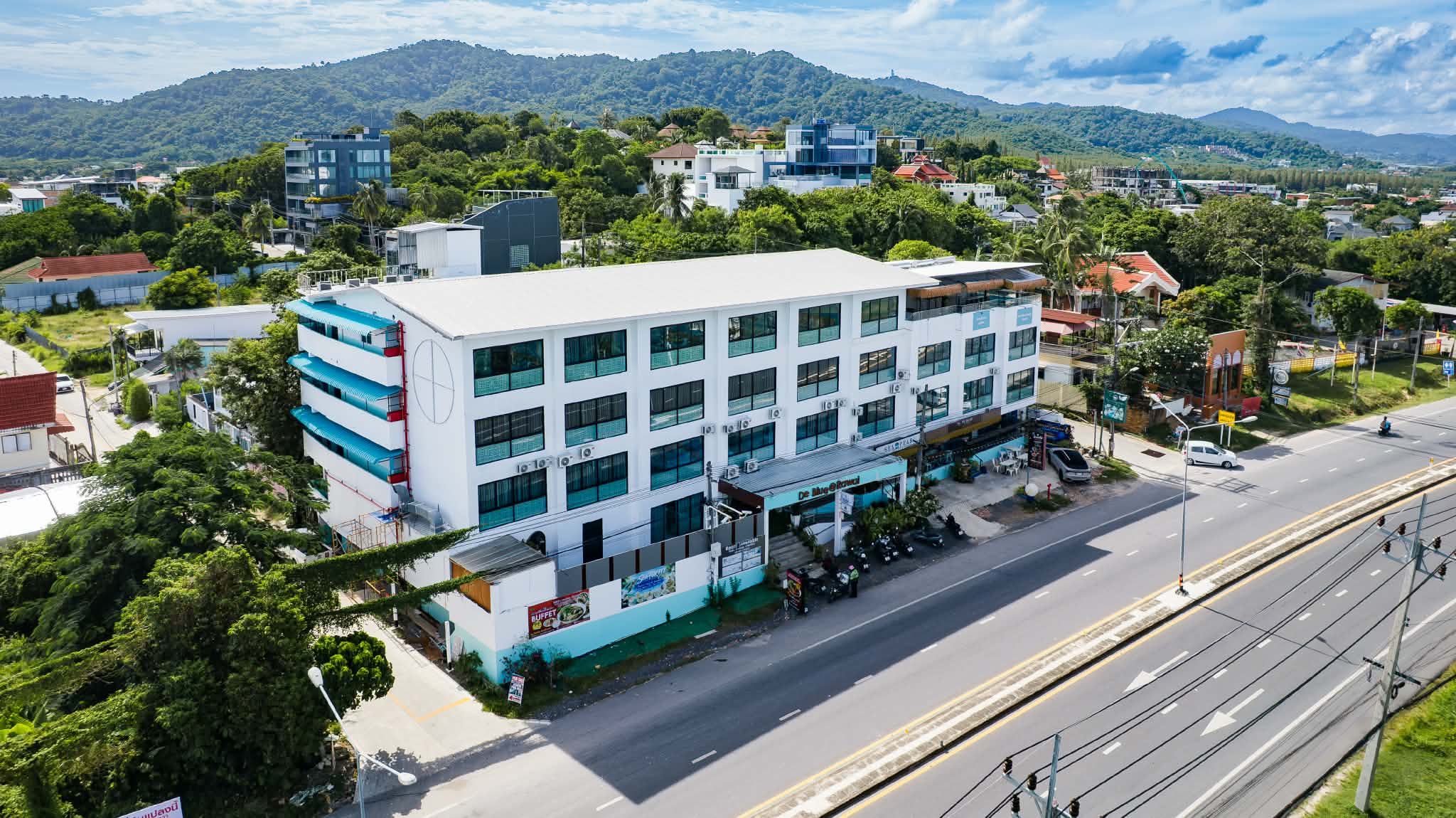 Side view of De Blue Sea Rawai Hotel with sea-view balconies and the Phuket hills